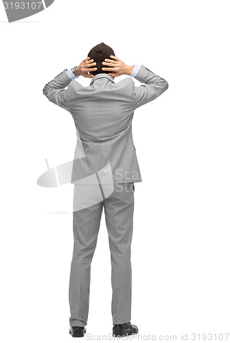 Image of businessman grabs his head from back