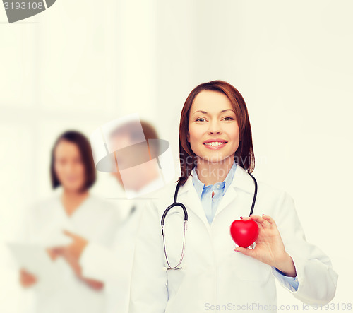 Image of smiling female doctor with heart and stethoscope