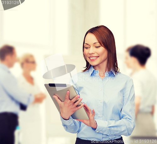 Image of smiling woman looking at tablet pc at office