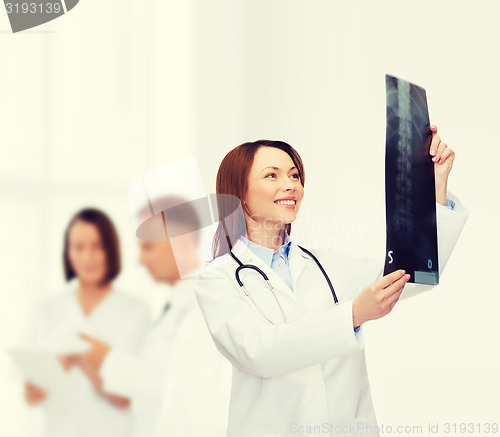 Image of smiling female doctor looking at x-ray