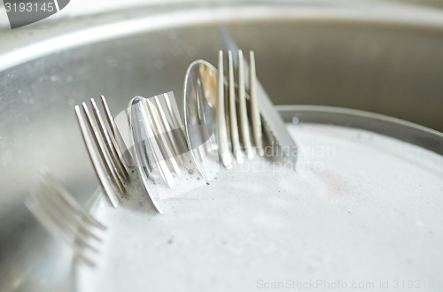 Image of close up of dirty dishes washing in kitchen sink