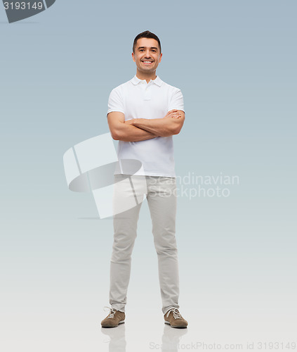 Image of smiling man with crossed arms over gray background