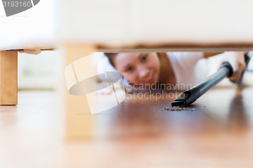 Image of close up of woman with vacuum cleaner at home