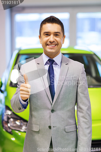 Image of man showing thumbs up at auto show or car salon