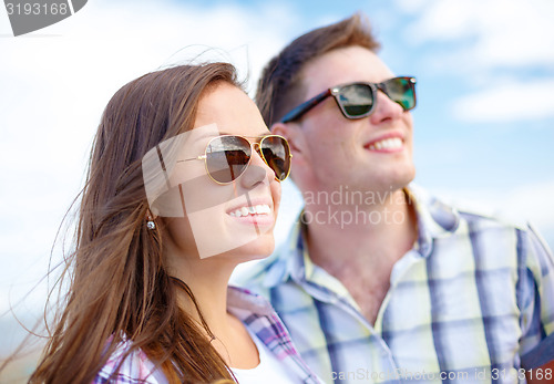 Image of smiling teenagers in sunglasses having fun outside