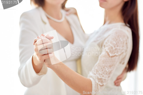 Image of close up of happy married lesbian couple dancing