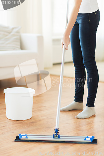 Image of close up of woman with mop cleaning floor at home