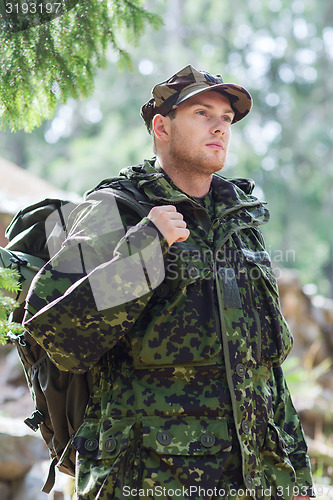 Image of young soldier with backpack in forest