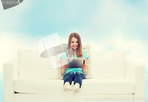 Image of little girl sitting on sofa with tablet pc