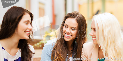 Image of beautiful girls talking in cafe