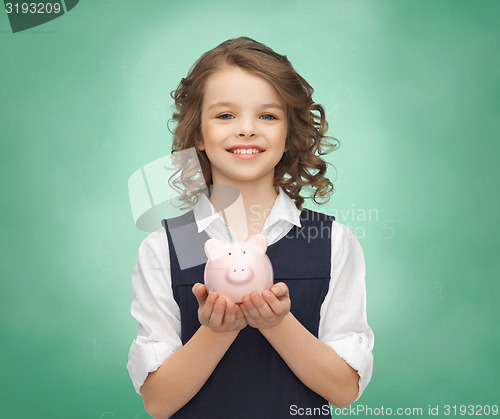 Image of happy girl holding piggy bank on palms