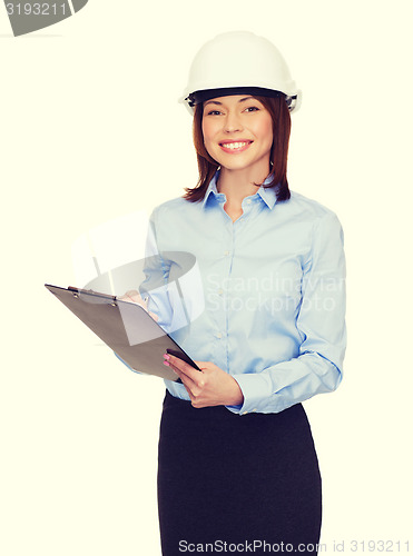 Image of smiling businesswoman in helmet with clipboard