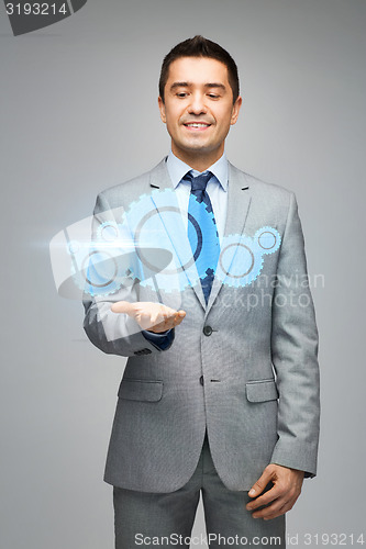 Image of happy businessman showing virtual projection