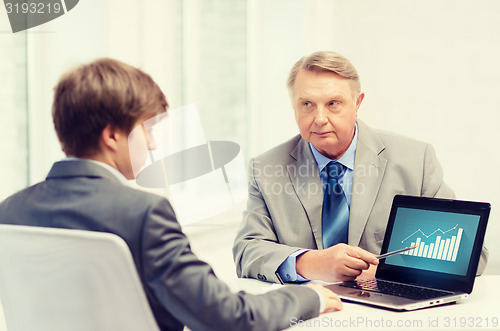 Image of older man and young man with laptop computer