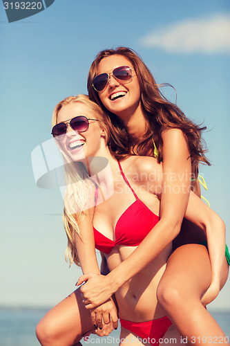 Image of two smiling young women on beach