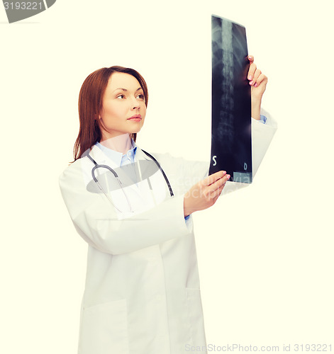 Image of serious female doctor looking at x-ray