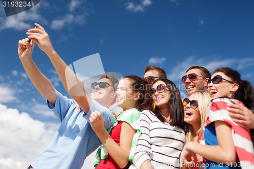 Image of group of friends taking selfie with cell phone