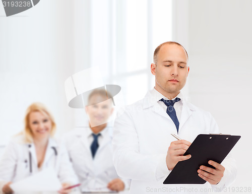 Image of serious male doctor with clipboard