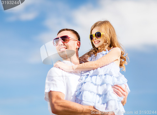 Image of happy father and child in sunglasses over blue sky