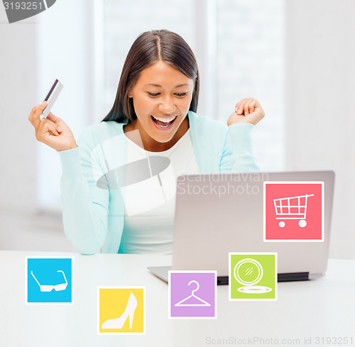 Image of happy businesswoman with laptop and credit card