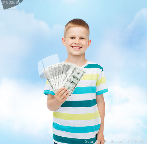 Image of smiling boy holding dollar cash money in his hand