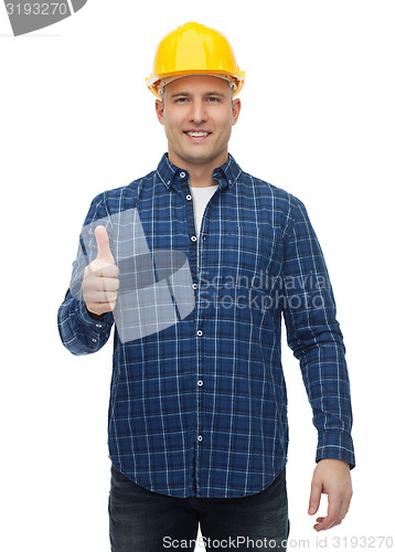 Image of smiling male builder in helmet showing thumbs up