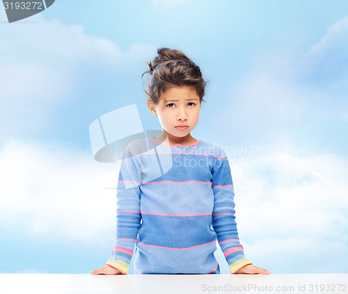 Image of sad little girl over city background