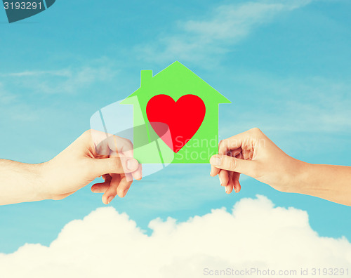 Image of couple hands holding green paper house