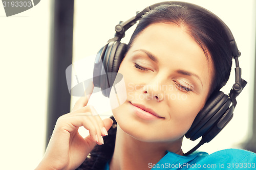 Image of happy teenage girl in big headphones