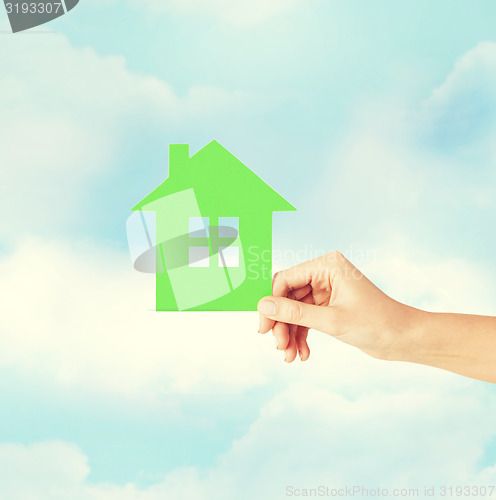 Image of hand holding green paper house