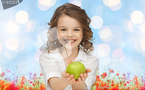 Image of happy girl holding apple over garden background