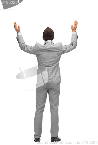 Image of businessman raising hands up from back