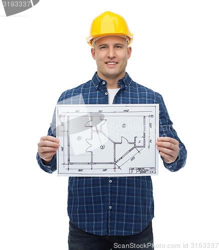 Image of smiling male builder in helmet with blueprint