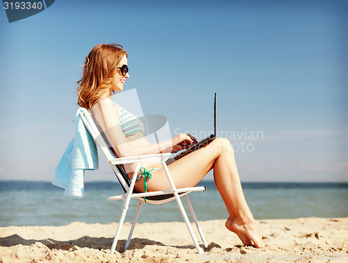 Image of girl looking at tablet pc on the beach