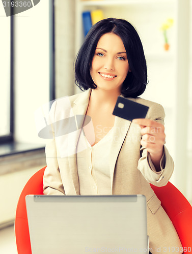 Image of businesswoman with laptop showing credit card