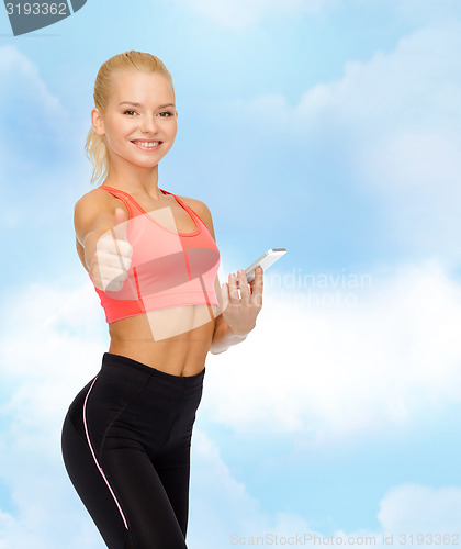 Image of smiling sporty woman with smartphone