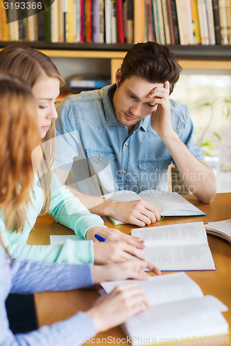 Image of students with books preparing to exam in library