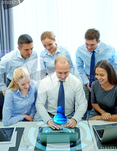 Image of smiling business people with laptop in office