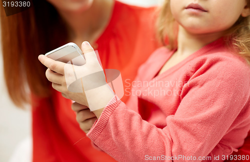 Image of close up of woman and little girl with smartphone