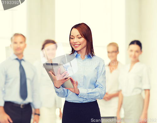 Image of smiling woman looking at tablet pc at office
