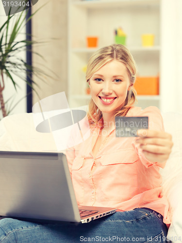 Image of happy woman with laptop computer and credit card