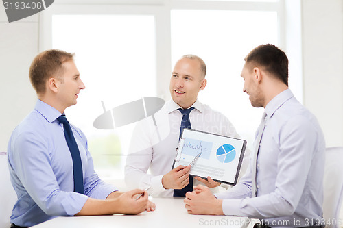 Image of smiling businessmen with papers in office