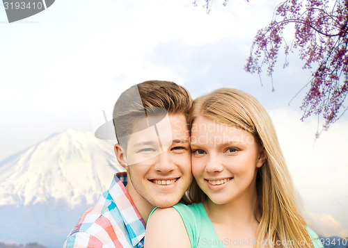 Image of smiling couple hugging over mountains background