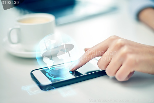 Image of close up of woman hand with smartphone and globe