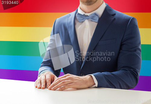 Image of close up of man in suit and bow-tie at table