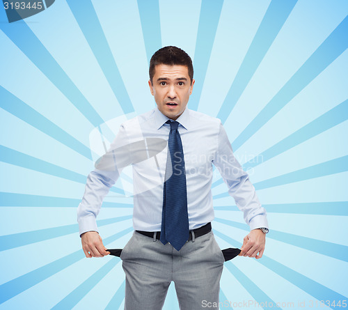 Image of surprised businessman showing empty pockets