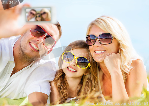 Image of happy family with camera taking picture