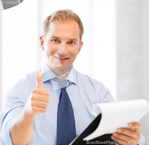 Image of businessman with papers showing thumbs up