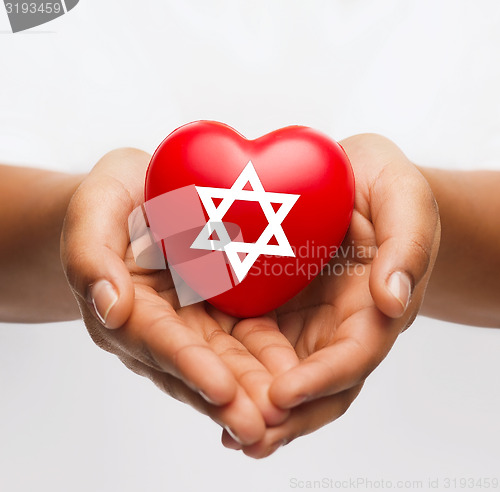 Image of female hands holding heart with star of david