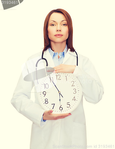 Image of calm female doctor with wall clock